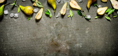 Sliced and whole pears with ice and leaves. On the stone table. Free space for text . Top view