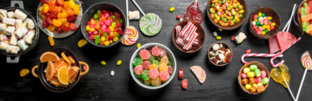 Different sweet candy, jelly and candied in a bowl. On the black chalkboard.