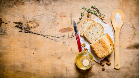 Fresh bread with oil , salt and herbs. On wooden background. Free space for text . Top view