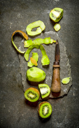 Fresh sliced kiwi with a knife on a stone stand. On the stone table. Top viewの写真素材