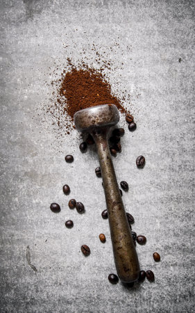 Pestle with ground coffee . On a stone background.の写真素材