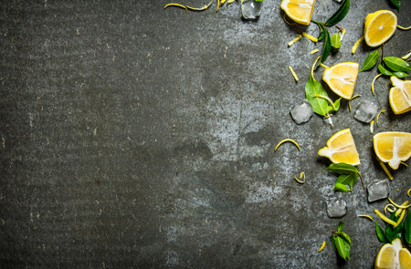 Slices of lemon, ice, leaves on the stone table. Free space for text . Top viewの写真素材