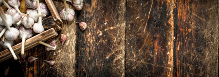 Garlic in an old box. On a wooden background.の写真素材