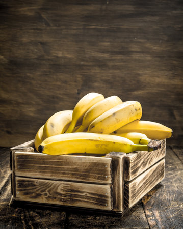 box of fresh bananas. On a wooden background.の写真素材