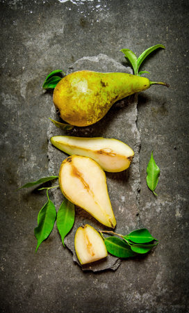 Fresh pears on a stone stand with leaves. On the stone table. Top viewの写真素材