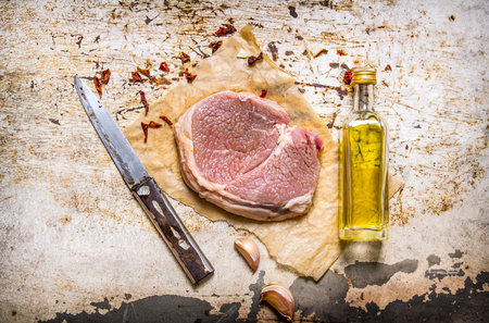 Raw steak with oil and spices. On the rustic background. Top viewの写真素材