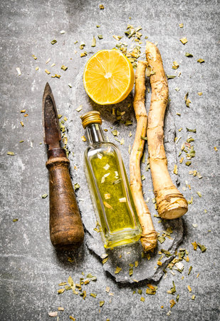 Old knife , spices with lemon and olive oil. On the stone table. Top viewの写真素材