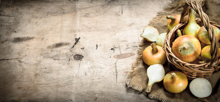 Fresh onions in a basket. On a wooden background.の写真素材
