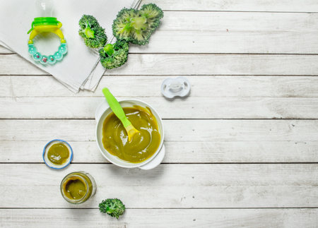 Baby food. Baby puree from broccoli. On a white wooden background.の写真素材