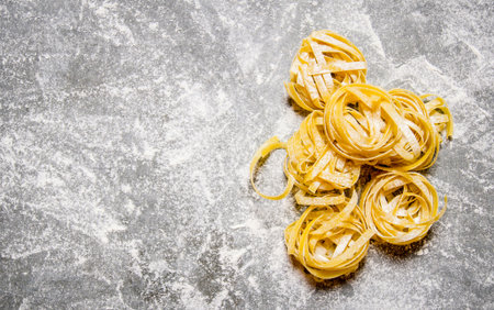 Dry pasta in flour. On the stone table. Free space for text . Top viewの写真素材