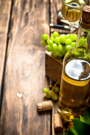 White wine with a box full of grapes. On a wooden table.の写真素材
