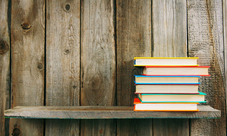 Books on a wooden shelf. On a wooden background.の写真素材