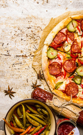 Tasty pizza with pepperoni and tomato sauce. On rustic background. Top viewの写真素材