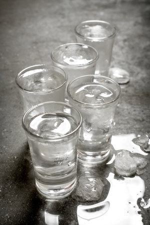 The vodka glass with ice. On the stone table.の写真素材