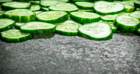 Pieces of fresh cucumbers . On a rustic background.の写真素材