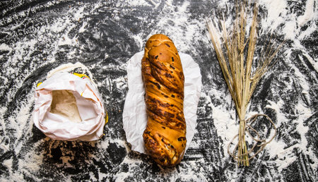 Set with ciabatta, flour and ears of wheat. On the table with flour. Top view
