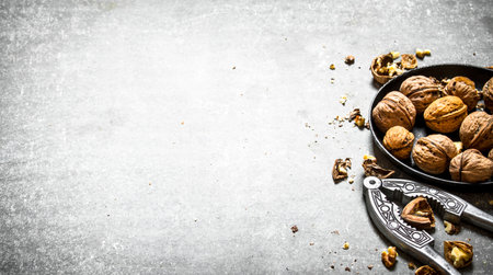 Walnuts in bowl with Nutcracker. On the stone table.