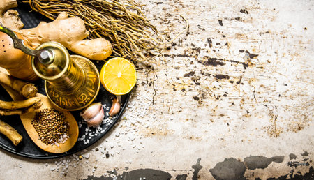 Old mill with spices and herbs on the tray. On rustic background. Free space for text . Top view