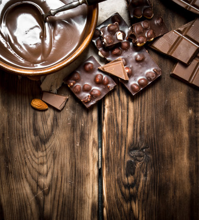 Chocolate cream with slices of chocolate and nuts. On a wooden table.の写真素材