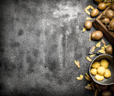 Fresh peeled potatoes . On the rustic background.の写真素材