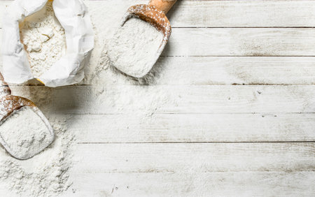 Flour in bag with a shovel. On a white wooden table.の写真素材
