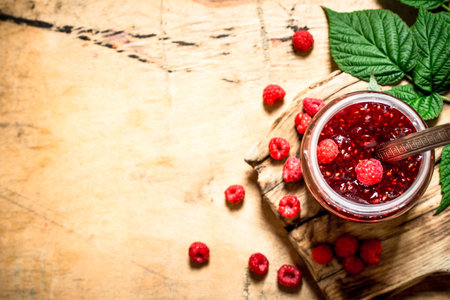 Sweet jam with raspberries. On a wooden table.の写真素材