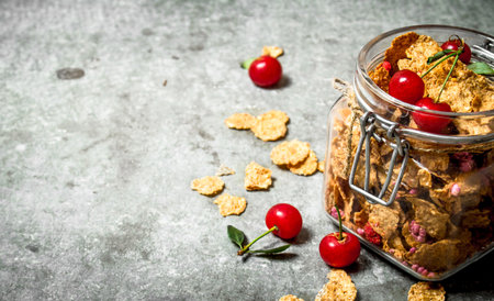 Healthy Breakfast. Muesli with cherries in a jar . On the stone table.の写真素材