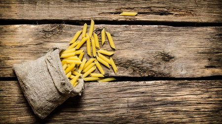 Dry pasta in the old bag. On the wooden background. Free space for text . Top viewの写真素材