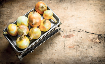 Fresh onion on the scales. On a wooden background.の写真素材