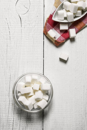 Refined sugar in the Cup. On a white wooden background.の写真素材