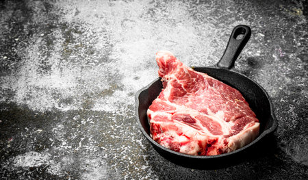 Raw beef steak in a pan. On rustic background.の写真素材