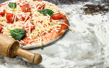 Unprepared pizza with ingredients. On a rustic background.の写真素材