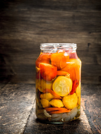 Marinated tomatoes in glass jar. On a wooden background.の写真素材