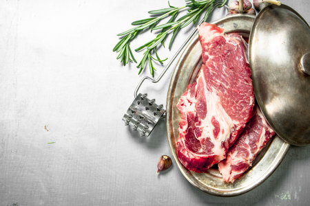 Fresh raw beef steak with spices. On rustic background.の写真素材
