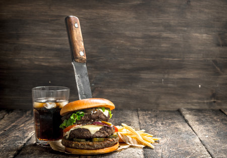 Big burger with cola and fries. On a wooden background.の写真素材