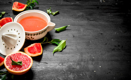 Fresh juice from grapefruits. On a black chalkboard.の写真素材