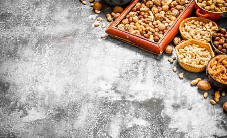 A lot of nuts in different bowls. On rustic background.の写真素材