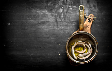 Salted herring with spices and herbs. Black chalkboard.の写真素材