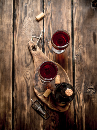 Red wine on wooden Board with stoppers and a corkscrew. On a wooden table.の写真素材