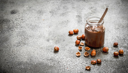 nut butter from hazelnuts and chocolate. On rustic background.