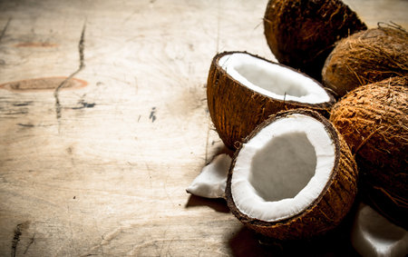 Fresh hard coconuts. On a wooden background .