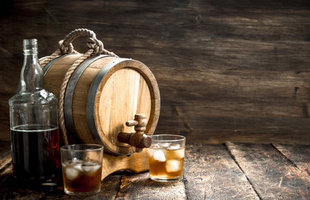 barrel of Scotch whiskey with a glass. On a wooden background.の写真素材
