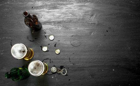 Glasses with beer, stoppers and opener. On the black chalkboard.の写真素材