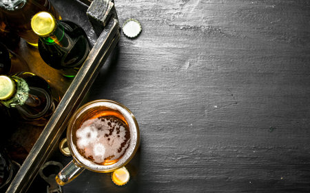 Fresh beer in an old box. On the black chalkboard.の写真素材