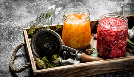 Marinated cabbage with herbs and seamer on a tray. On a rustic background.