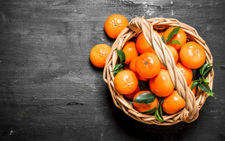 Fresh tangerines in the basket. On a black chalkboard.の写真素材