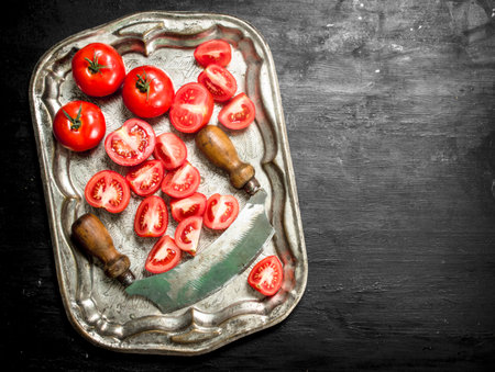 liced tomatoes on a steel tray. On black chalkboard.の写真素材