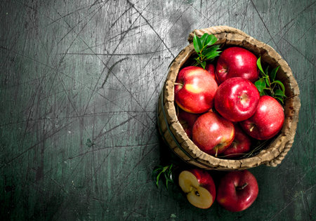 Red apples in a wooden bucket. On a rustic background.の写真素材
