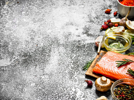 Raw fish. Fresh salmon fillet with herbs and spices. On rustic background.の写真素材