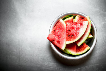 Chopped watermelon in a bowl. On the metal table.の写真素材